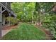 Manicured backyard featuring lush green lawn and landscaped garden beds at 18730 Floyd Ct, Davidson, NC 28036