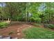 Lush backyard with mature trees, landscaping, and a stepping stone pathway at 18730 Floyd Ct, Davidson, NC 28036