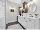 Elegant bathroom with marble countertop, modern mirrors, dual sinks and dark hardware at 18730 Floyd Ct, Davidson, NC 28036