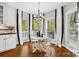 Bright breakfast nook features a round table, white chairs, and black and white curtains by large windows at 18730 Floyd Ct, Davidson, NC 28036