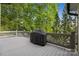 Back deck with a closed grill and railing overlooking mature trees at 18730 Floyd Ct, Davidson, NC 28036