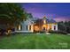 Charming two-story home with manicured lawn and stone accents, beautifully lit at dusk at 18730 Floyd Ct, Davidson, NC 28036