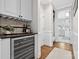 Hallway with wine refrigerator, built in shelving and a view to the laundry room, creating a functional transition space at 18730 Floyd Ct, Davidson, NC 28036