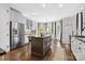 Spacious kitchen with a central island, stainless steel appliances, and dark hardwood floors, connecting seamlessly to dining area at 18730 Floyd Ct, Davidson, NC 28036