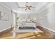 Serene main bedroom with tray ceiling, neutral decor, hardwood floors, and large windows for a bright, peaceful retreat at 18730 Floyd Ct, Davidson, NC 28036