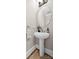 Classic powder room featuring a pedestal sink, round mirror, and neutral wall paint, offering a simple yet elegant space at 18730 Floyd Ct, Davidson, NC 28036
