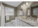 Bathroom featuring double sinks, granite countertops, and white cabinetry, exuding style and functionality at 2100 Shadyview Dr, Charlotte, NC 28210