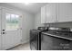 This well-lit laundry room features new washer and dryer with white cabinets above at 2100 Shadyview Dr, Charlotte, NC 28210
