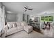 Open living area features a comfortable sofa, ceiling fan, and an eat-in kitchen with a large window at 2100 Shadyview Dr, Charlotte, NC 28210