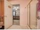 Pink bathroom with glass shower, toilet and bedroom view via doorway at 2478 23Rd Ne St, Hickory, NC 28601