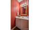 Cozy powder room with charming vanity, mirror and red and white striped walls at 2478 23Rd Ne St, Hickory, NC 28601