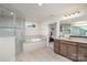 Modern bathroom showcasing a walk-in shower, a soaking tub, and a vanity with granite countertops at 3925 Tokay Ln, Fort Mill, SC 29707