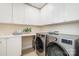 Efficient laundry room with modern washer and dryer, ample storage cabinets, and counter space at 3925 Tokay Ln, Fort Mill, SC 29707