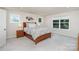 Cozy bedroom featuring a wooden bed frame, soft carpet, neutral decor, and natural light from multiple windows at 3925 Tokay Ln, Indian Land, SC 29707