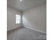 Minimalist bedroom with neutral walls, carpet, and a bright window at 4142 Longmore Ln, Kannapolis, NC 28081