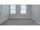 Cozy bedroom featuring plush gray carpeting and dual windows for natural light at 4142 Longmore Ln, Kannapolis, NC 28081