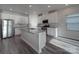 Bright kitchen showcases white cabinetry, stainless steel appliances, a center island, and wood-look flooring at 4142 Longmore Ln, Kannapolis, NC 28081
