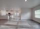 Spacious open floor plan with gray wood floors, leading to the kitchen with island and white cabinets at 4142 Longmore Ln, Kannapolis, NC 28081