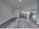 Open-concept living room with light gray wood floors, kitchen, and natural light at 4142 Longmore Ln, Kannapolis, NC 28081