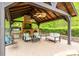 Covered outdoor living space featuring a brick fireplace, grill, comfortable seating, and ceiling fans at 4600 Spicewood Dr, Charlotte, NC 28227