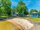 Aerial view of waterfront property with beach, house, guest house, and lush landscaping at 5200 Masons Ferry Rd, Clover, SC 29710