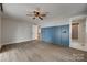 Bright main bedroom with hardwood floors, blue accent wall, ceiling fan, and bathroom access at 5200 Masons Ferry Rd, Clover, SC 29710