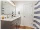 Bright bathroom features double sinks, dark cabinets, white countertops, and a blue striped shower curtain at 5804 Crosswinds Ct, Indian Trail, NC 28079