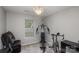 Exercise room featuring exercise bike, weight machine, chair and a stylish light fixture at 5804 Crosswinds Ct, Indian Trail, NC 28079