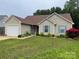 Inviting one-story home featuring a lush front yard with a garage and pleasing exterior siding at 5804 Crosswinds Ct, Indian Trail, NC 28079