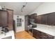 Kitchen featuring wood floors, dark cabinetry, modern appliances, and ample countertop space at 5804 Crosswinds Ct, Indian Trail, NC 28079