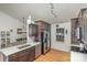 Eat-in kitchen featuring wooden floors, black cabinetry, modern stainless-steel appliances, and bright lighting at 5804 Crosswinds Ct, Indian Trail, NC 28079
