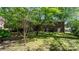 Large, grassy backyard with mature trees, a deck, and a brick home exterior at 634 7Th Avenue Se Pl, Hickory, NC 28602