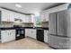 Well-lit kitchen with stainless steel refrigerator, black appliances, and white cabinets, and a stylish backsplash at 634 7Th Avenue Se Pl, Hickory, NC 28602