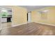 Spacious room with new flooring that connects to a kitchen with white cabinetry and black appliances at 634 7Th Avenue Se Pl, Hickory, NC 28602