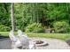 Relaxing backyard with a stone fire pit and wooden bridge surrounded by lush greenery at 6425 High Creek Ct, Charlotte, NC 28277