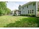 Large grassy backyard with an adjacent screened porch and a wooden fence at 6425 High Creek Ct, Charlotte, NC 28277