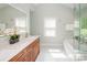 Well-lit bathroom features white marble floors, dual sink vanity, large mirrors, and separate shower and bath at 6425 High Creek Ct, Charlotte, NC 28277