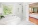 Bright bathroom with a glass shower, soaking tub, marble tile floor, and a bedroom view at 6425 High Creek Ct, Charlotte, NC 28277