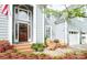 Inviting front porch with a seating area, beautiful flowerbeds, and a stylish front door at 6425 High Creek Ct, Charlotte, NC 28277