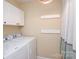 Bright laundry room boasts cabinetry and modern machines at 6425 High Creek Ct, Charlotte, NC 28277