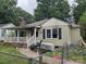 Side view of a neglected single-story home with a white porch, showing fire damage and overgrown yard at 721 S Spruce St, Rock Hill, SC 29730