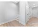 Hallway featuring wood floors, stairs, and white trim, leading to additional living spaces at 722 Falling Oak Aly # 20, Huntersville, NC 28078