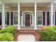 Charming home with a welcoming front porch, columns, and manicured landscaping at 7716 Seton House Ln, Charlotte, NC 28277