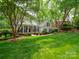 Lush green lawn and mature trees surround this home at 7716 Seton House Ln, Charlotte, NC 28277
