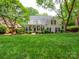 Charming home featuring a second story balcony, dark shutters, and lush landscaping at 7716 Seton House Ln, Charlotte, NC 28277