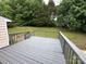 Grey painted back deck offering outdoor living space overlooking green trees at 8000 Tiburon Cir, Charlotte, NC 28215