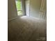 Bedroom with neutral walls, plush carpeting, and a window providing natural light at 8000 Tiburon Cir, Charlotte, NC 28215