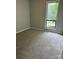 Bedroom with neutral walls, plush carpeting, and a bright window at 8000 Tiburon Cir, Charlotte, NC 28215