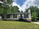 Charming single-story home with neutral siding, black shutters, brick foundation and well-maintained front lawn at 8000 Tiburon Cir, Charlotte, NC 28215