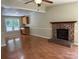 Inviting living room with brick fireplace, wood floors, and bright natural light from large windows at 8000 Tiburon Cir, Charlotte, NC 28215